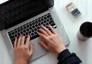 Handen die digitale content creëren op een laptop